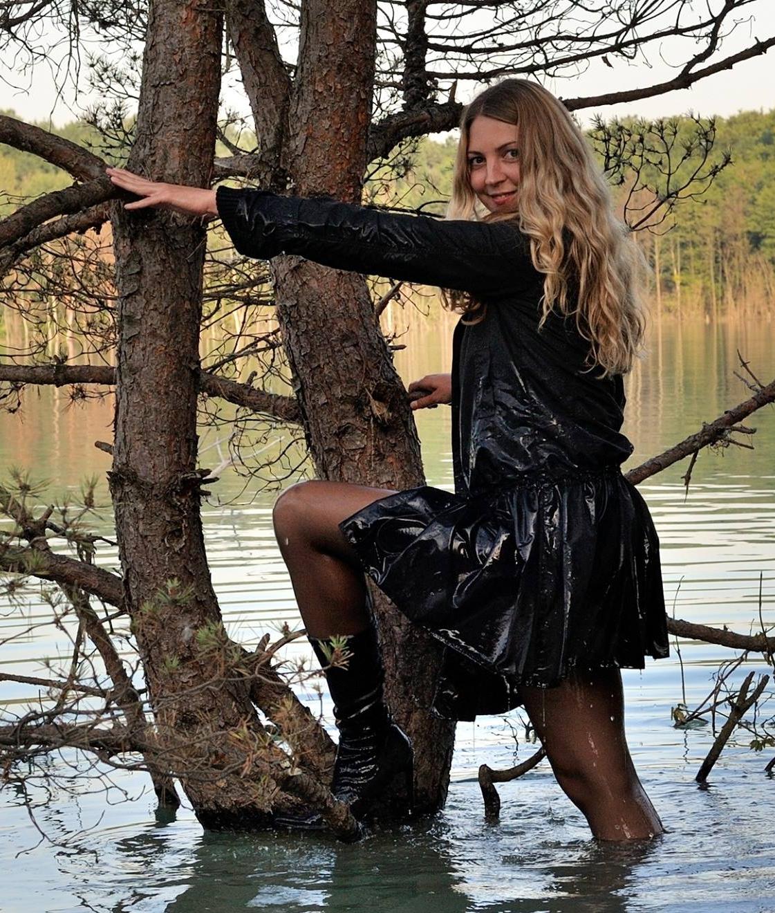 Blonde Young Woman wearing Wet Black Pantyhose and Black Raincoat